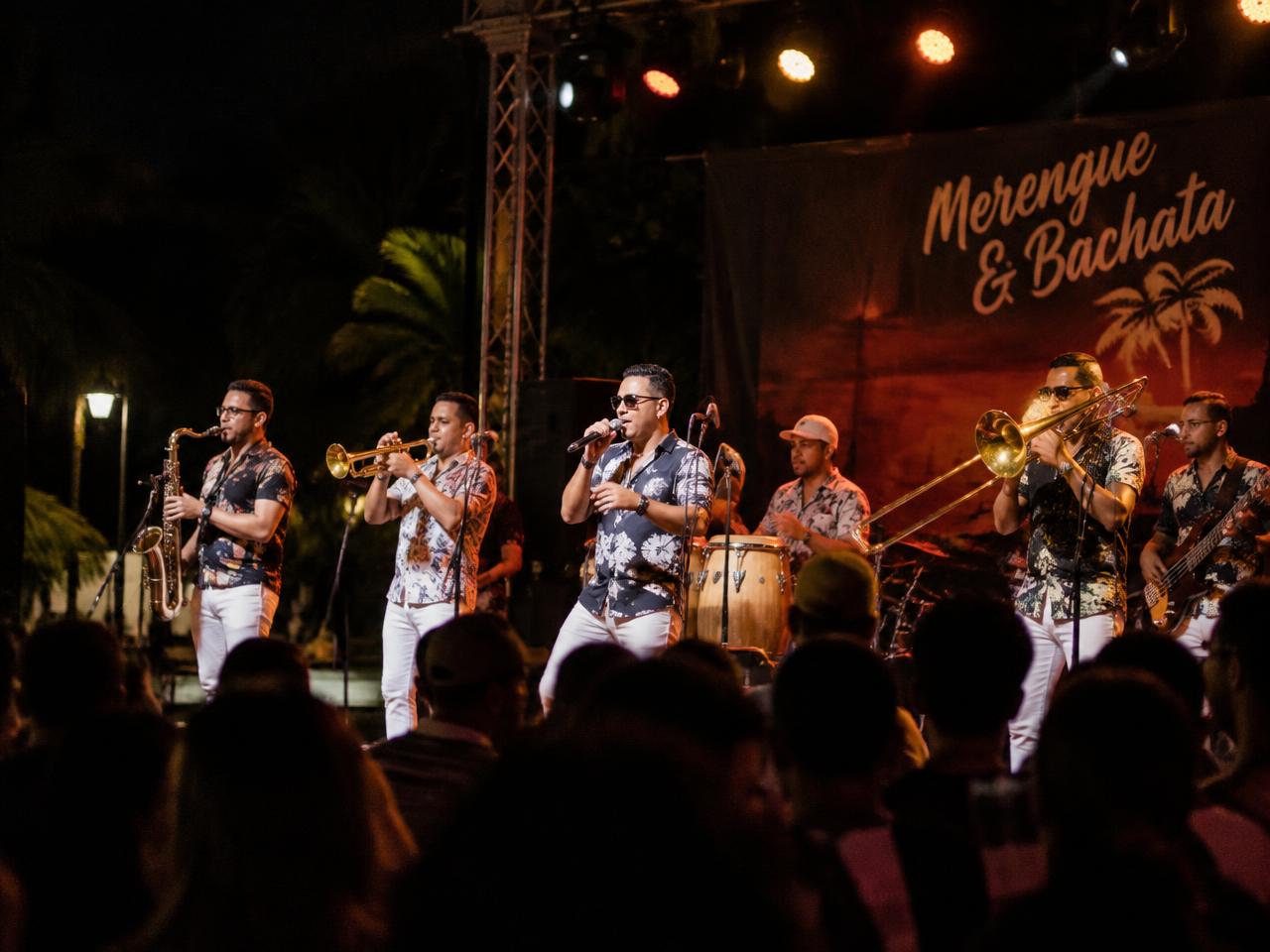 Live merengue band performing outdoors at night